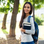 45832161 – portrait of a beautiful smiling student standing outdoors with books
