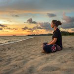 41846180 – woman sitting on beach sand and relaxing at sunset time