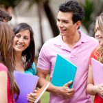 9514016 – group of students talking and holding notebooks outdoors