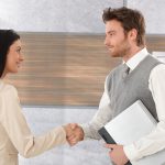 9201850 – young businesspeople greeting each other by shaking hands, smiling.