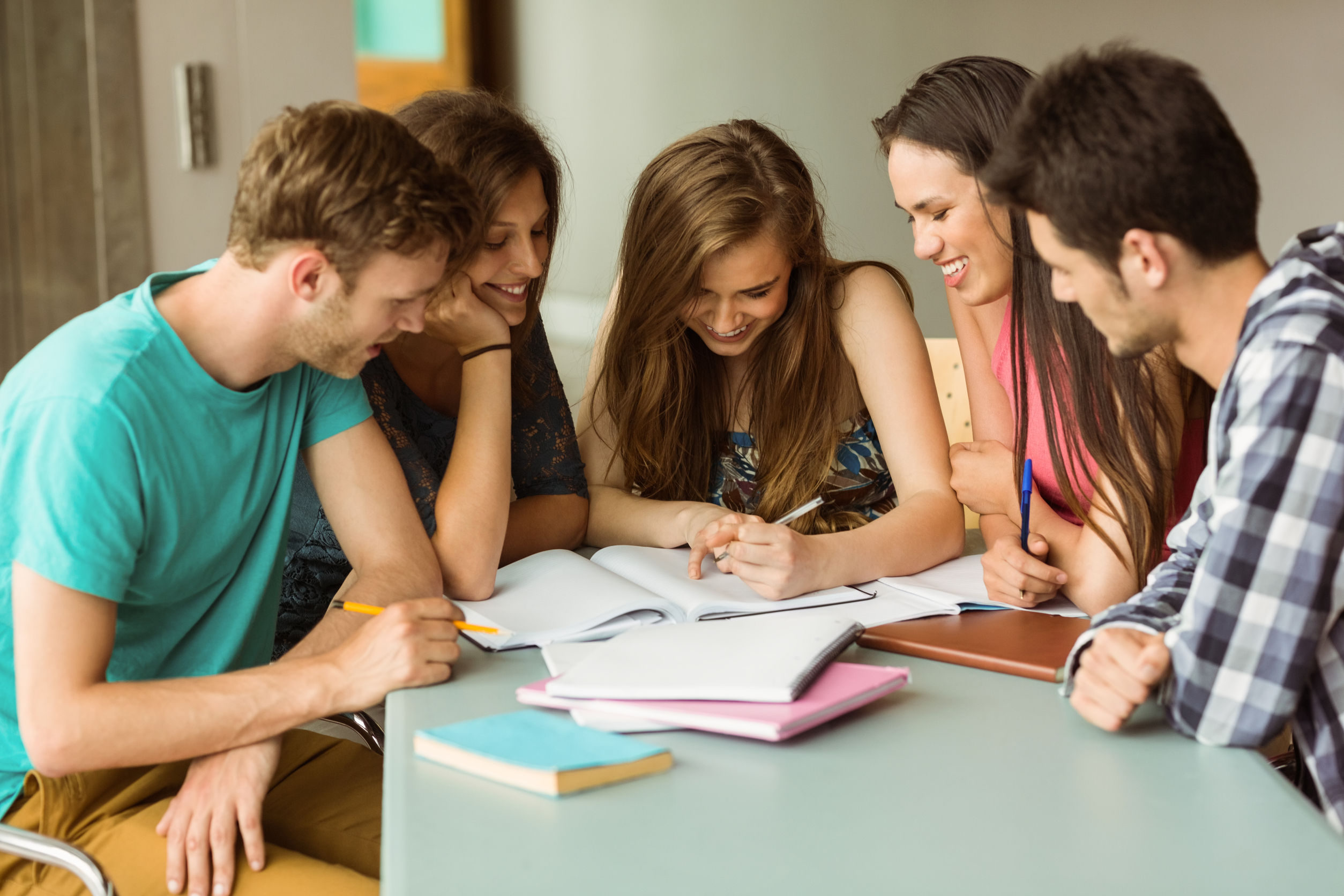 36411247 - smiling friends sitting studying together after school - SoGood Languages