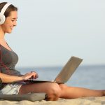 41597993 – teen girl studying with a laptop on the beach leaning on a bicycle